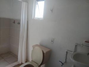 a bathroom with a toilet and a sink and a window at Departamentos y Cuartos Apaxco in Apaxco de Ocampo