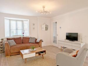 a living room with a couch and a tv at Shell Seekers - Selsey in Selsey