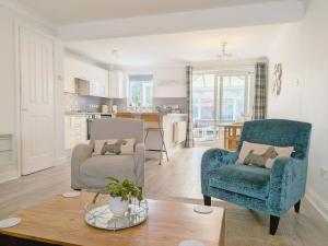 a living room with two chairs and a table at Shell Seekers - Selsey in Selsey