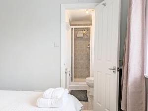 a bathroom with a bed and a toilet and a shower at Shell Seekers - Selsey in Selsey +17 photos