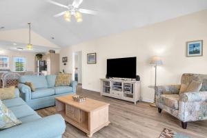 a living room with blue furniture and a flat screen tv at No Worries in Oak Island +39 photos