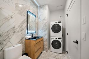 a bathroom with two washing machines and a sink at Le Nomade Quartier Chinois in Montreal