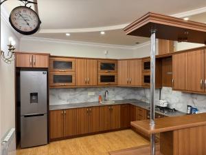 a kitchen with wooden cabinets and a clock on the wall at Afyan's guest house in Yerevan