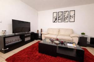 a living room with a couch and a flat screen tv at Rinconcito de Paz en Xalapa in Xalapa