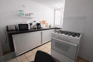 a kitchen with a white stove and a counter top at Rinconcito de Paz en Xalapa in Xalapa +17 photos