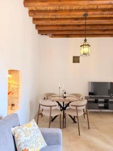 a living room with a table and chairs and a tv at Estia Vouni Boutique Houses in Vouni