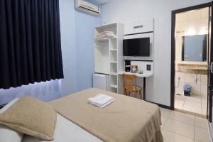a small room with a bed and a television at Esplendor Palace Hotel in Vitória da Conquista