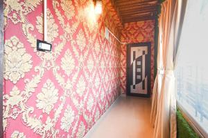 a room with a pink wall with a curtain at Hotel O Champasari Siliguri Formerly Four Fox Suits in Siliguri +29 photos