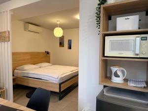 a small bedroom with a bed and a microwave at MAKS 2 Osijek Center, self check in in Osijek +18 photos