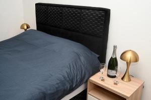 a bedroom with a bed and two wine glasses on a night stand at Elysium1 in Banja Luka