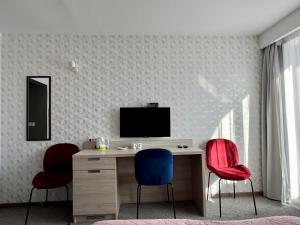 a room with a desk with two chairs and a television at WiLLA APART in Władysławowo +115 photos