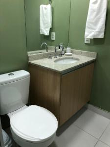 a bathroom with a toilet and a sink with a mirror at Studio Praça Tatuapé in São Paulo +7 photos