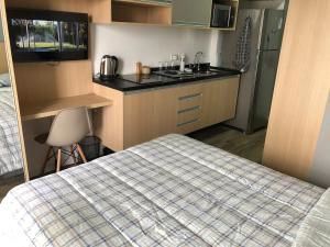 a small kitchen with a bed and a sink at Studio Praça Tatuapé in São Paulo