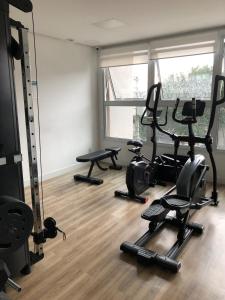 a gym with several treadmills and exercise equipment in a room at Studio Praça Tatuapé in São Paulo