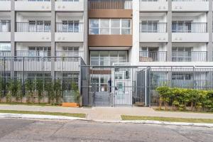 a large building with a gate in front of it at Studio Praça Tatuapé in São Paulo