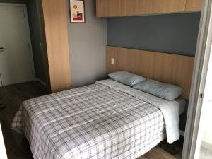 a small bedroom with a bed with a blanket at Studio Praça Tatuapé in São Paulo