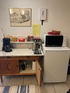 a kitchen with a counter with a microwave and a table at Rum i villa - Kärleksudden Norrtälje in Norrtälje