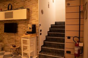 a living room with a staircase and a fireplace at Al Civico 23 in Castiglione del Lago