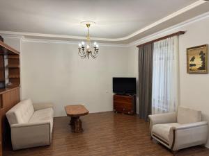 a living room with two chairs and a table and a television at Afyan's guest house in Yerevan