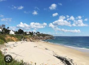 a beach with people on the sand and the ocean at Maison de ville quartier saint-pierre in Brest