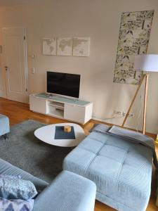 a living room with a tv and a couch at Am Schlosspark Potsdam in Potsdam