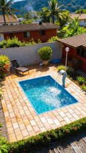 a swimming pool with a fountain in a yard at Alfa Serra lago e montanha in Guapimirim