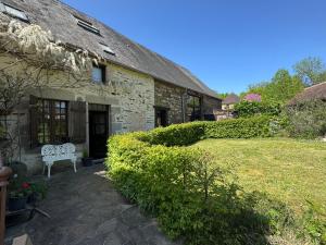 an old stone house with a bench in the yard at La poésie de l'instant in Bétête