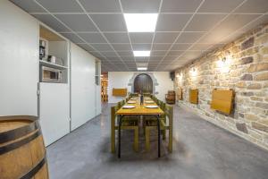 a row of tables in a room with a brick wall at Le Xilotik Gîte in Espelette +12 photos