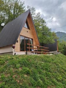 a wooden cabin with a large window on a hill at Vikendice Limski mir in Andrijevica +15 photos