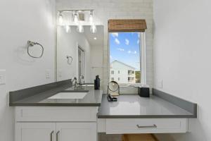 a white bathroom with a sink and a mirror at North Topsail Beach - Beachfront, Pool & HotTub in North Topsail Beach +122 photos