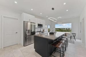a kitchen with a large island with bar stools at North Topsail Beach - Beachfront, Pool & HotTub in North Topsail Beach