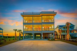 a large building with palm trees in front of it at North Topsail Beach - Beachfront, Pool & HotTub in North Topsail Beach