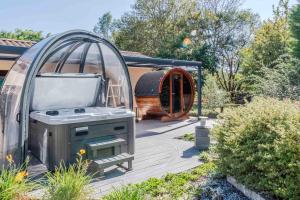 a barbecue in a greenhouse next to a house at L'Escale Sud Gironde - Séjour en amoureux avec jacuzzi privatif - Piscine - Massage Traiteur & Brunch possibles in Pompéjac