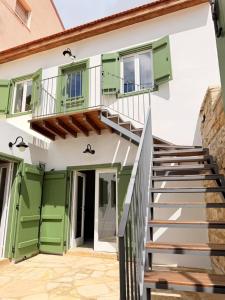 a house with green and white doors and stairs at Estia Vouni Boutique Houses in Vouni +18 photos