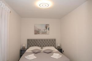 a bedroom with a bed with two towels on it at Apartments Old Town in Trogir
