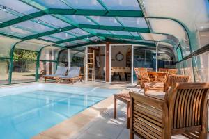 a swimming pool with chairs and a table at L'Escale Sud Gironde - Séjour en amoureux avec jacuzzi privatif - Piscine - Massage Traiteur & Brunch possibles in Pompéjac