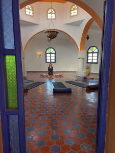 a room with two people sitting in a yoga class at Swellora Surf Camp Imsouane in Imsouane