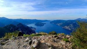 a person sitting on top of a mountain overlooking a lake at Casa Zia Adry in Zone