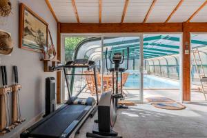 a gym with a treadmill and a swimming pool at L'Escale Sud Gironde - Séjour en amoureux avec jacuzzi privatif - Piscine - Massage Traiteur & Brunch possibles in Pompéjac