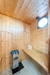 a wooden sauna with a stove and a window at Ainos Louanges - Bail Partner in Auxerre +37 photos