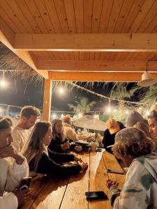 a group of people sitting around a wooden table at Swellora Surf Camp Imsouane in Imsouane