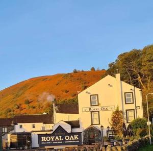 a train traveling past a building with a train station at Royal Oak Braithwaite in Keswick
