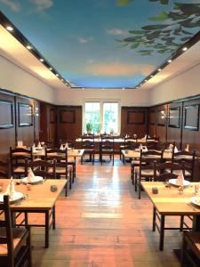 a dining room with tables and chairs and a painting on the ceiling at Landhotel Vosse-Schepers in Rhede