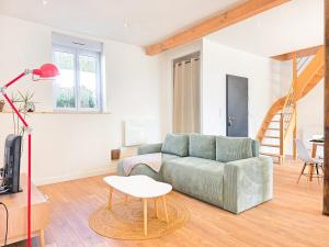 a living room with a couch and a table at Le Sauge, 5 min Gare, Terrasse, Stationnement in Saint-Brieuc