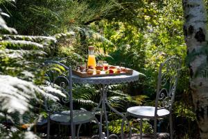 a table with a bottle of juice and fruit on it at L'Escale Sud Gironde - Séjour en amoureux avec jacuzzi privatif - Piscine - Massage Traiteur & Brunch possibles in Pompéjac