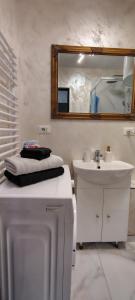 a white bathroom with a sink and a mirror at Studio roberto in Piatra Neamţ