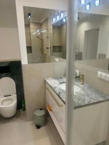 a bathroom with a toilet and a sink and a mirror at Apartament Ablewicza VIP in Tarnów +5 photos