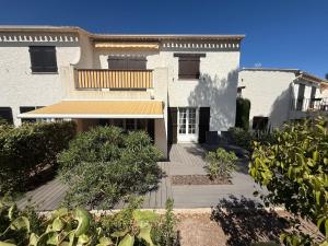 a white house with a porch and a balcony at Le Charme bleu d'Azur in Saint-Raphaël
