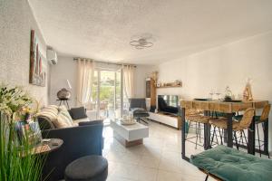 a living room with a couch and a table at Le Charme bleu d'Azur in Saint-Raphaël