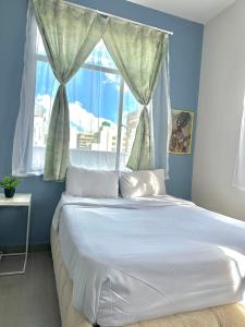 a bedroom with a large white bed with a window at Aegis building in Johannesburg
